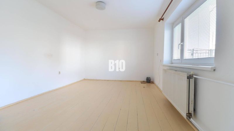 An empty room with a wood-patterned floor in a family house.