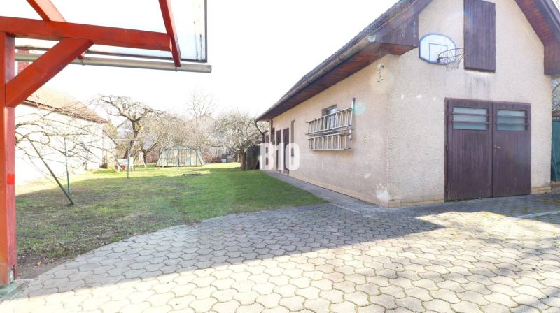 The courtyard of a family house in Turany with a garage and a basketball hoop.