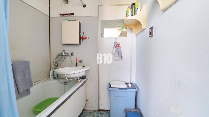 A bathroom with a shower curtain and a sink in a 3-room apartment.