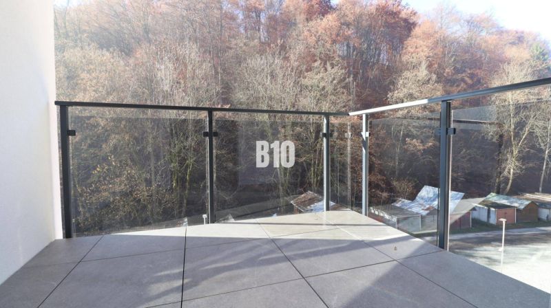 A balcony with glass railings and a forest view in Dolný Kubín, 2-room apartment.