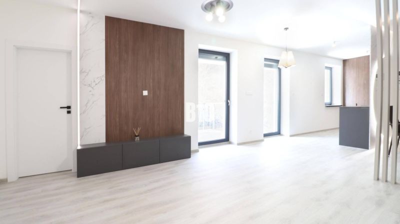 A bright interior of a 2-room apartment with a wood-patterned floor and large windows.