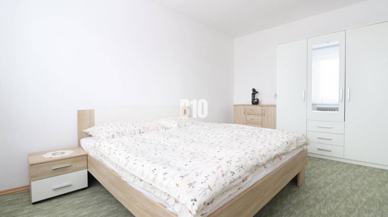 A bedroom with a wardrobe and a double bed in a 3-room apartment. The wardrobe has a mirror.