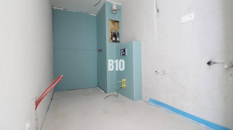 The interior of a 3-room apartment with an unfinished bathroom featuring installations and drywall.