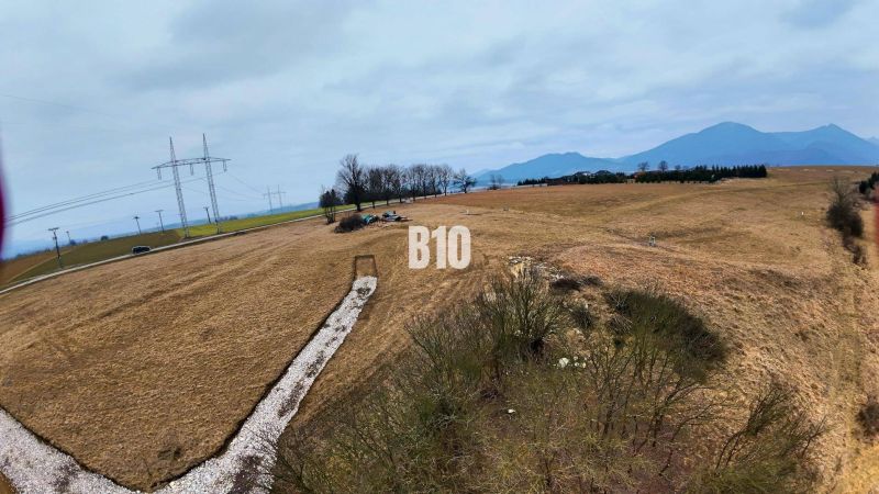Hilly landscape in Laskár suitable for residential plots, with power lines in the background.