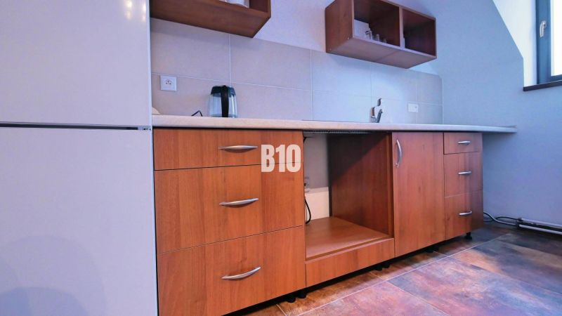 A kitchen unit with a wooden decor floor in a 3-room apartment.