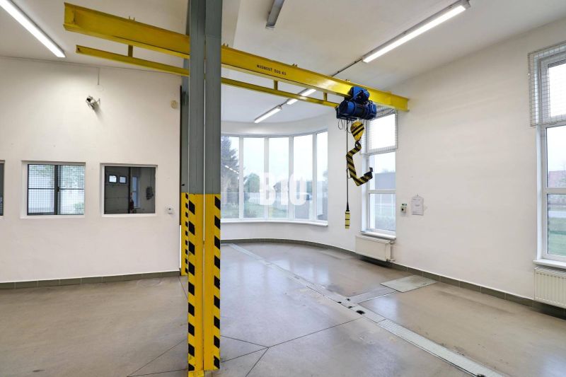 Crane space in a production area with a concrete floor and large windows.