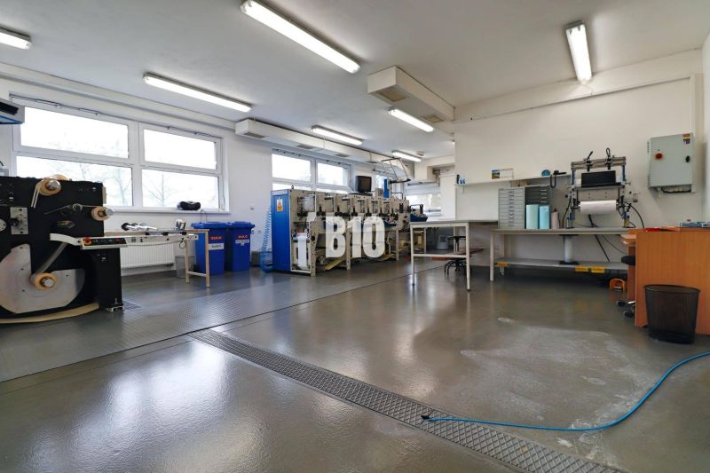 Manufacturing spaces with industrial machines and workbenches, clean and spacious interior.