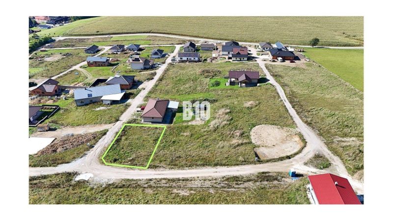 A residential plot in Necpaly, nestled among houses, ready for construction.