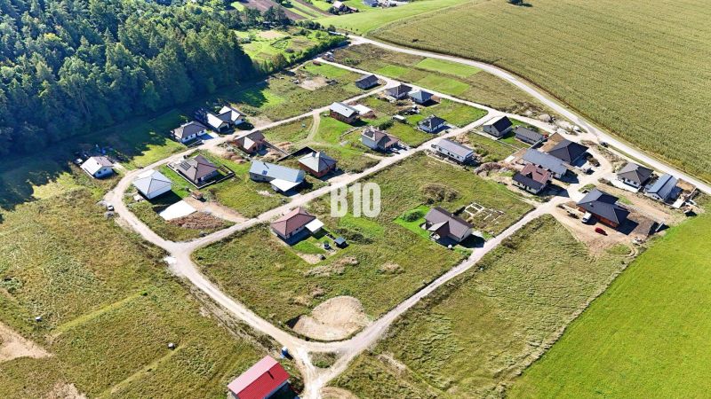 Aerial view of building plots in Necpaly surrounded by forests and agricultural landscape.