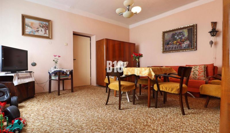 Living room in a family house, carpets, dark wood furniture, paintings on the walls.