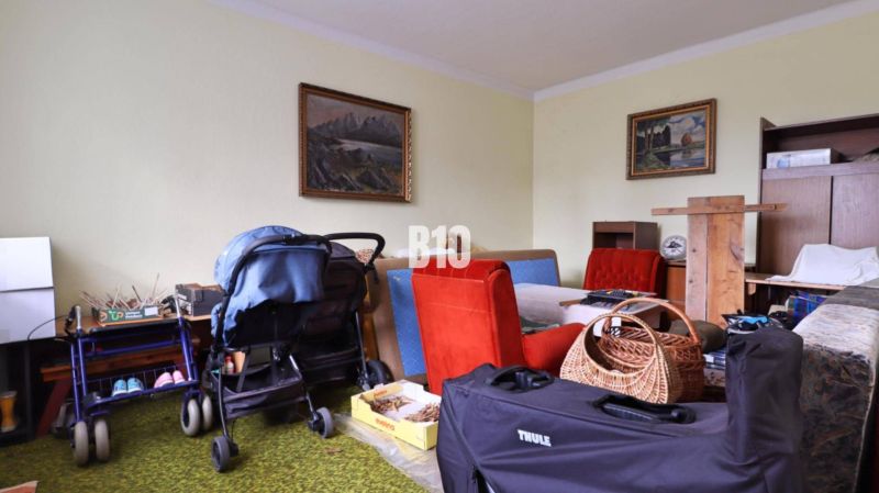 Interior with a stroller, furniture, and paintings in a family house.
