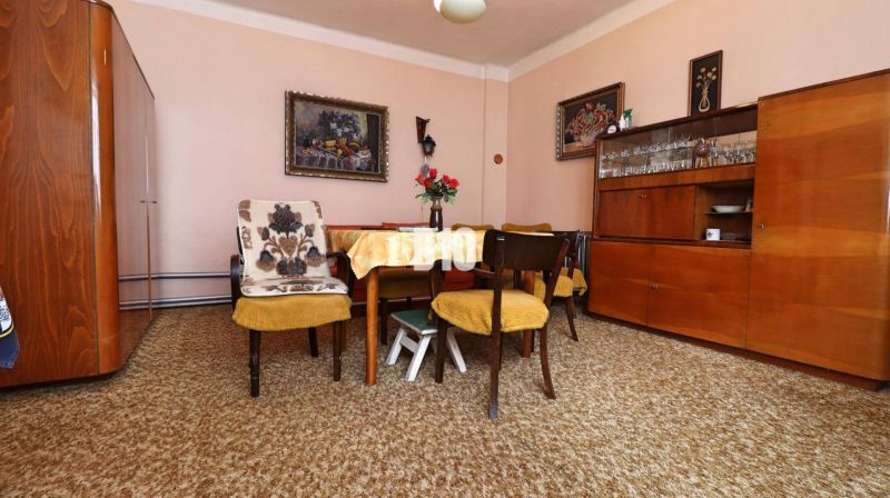 Dining room in a family house with wooden furniture, yellow chairs, carpets.