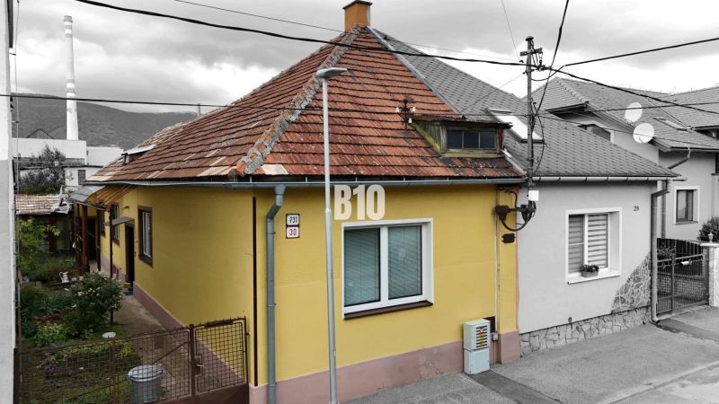 A family house in Martin with a yellow facade and a sloped roof, next to the access walkway.