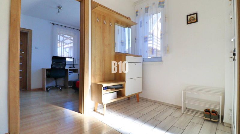 Entrance hall in a family house with wooden decor and a view of the study.