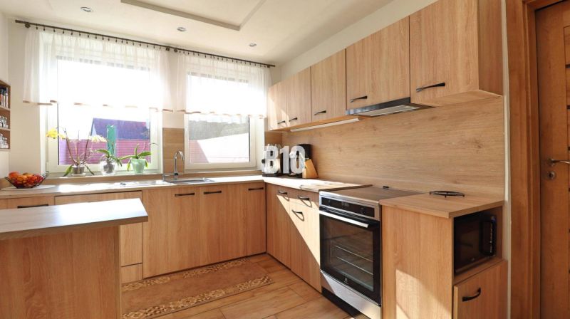 A kitchen in a family house with a wooden decor floor and furniture in light shades.