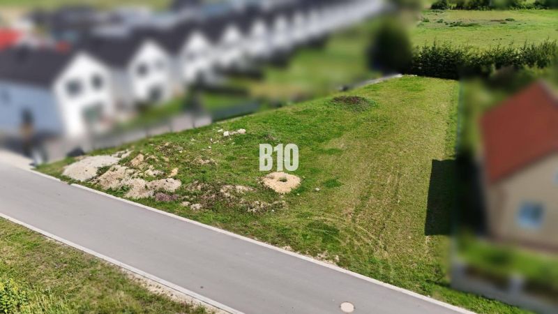 A plot suitable for living in Diakova with an access road and surrounding development.