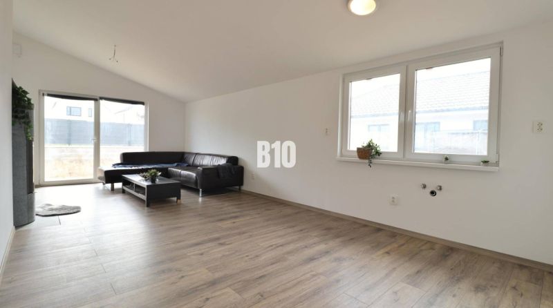 Living room in a family house, light sofa, wooden decor flooring, large windows.