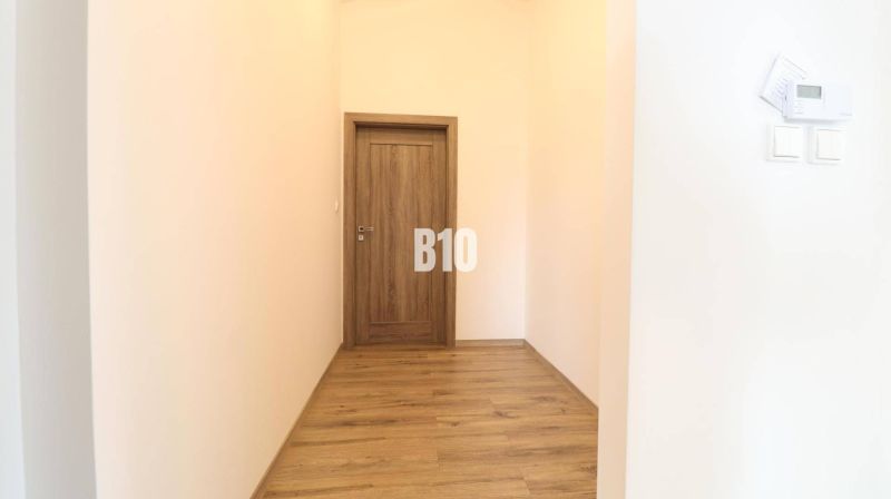 A hallway with doors and a floor with a wooden decor in a family house.