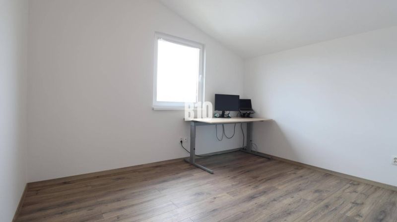 A room in a family house with a wooden decor floor and a work desk.