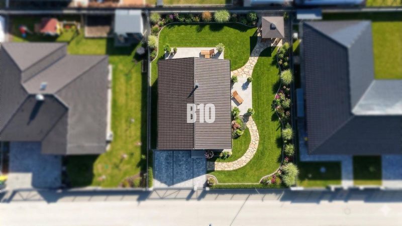 Aerial view of a family house in Diaková with a landscaped garden and a walkway.
