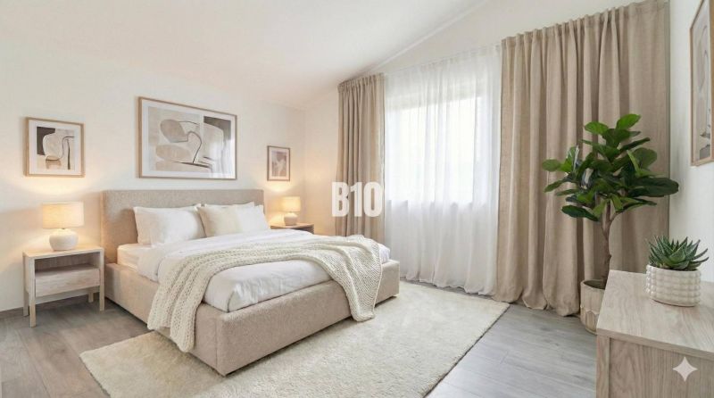A bright bedroom with a large bed, curtains, and plants in a family house.