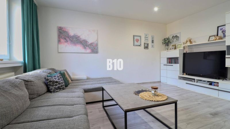 Living room with a comfortable couch and wall decorations in a two-room apartment.
