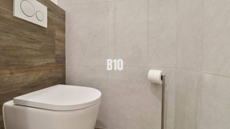 A bathroom with a toilet and wooden decor in a 3-room apartment.