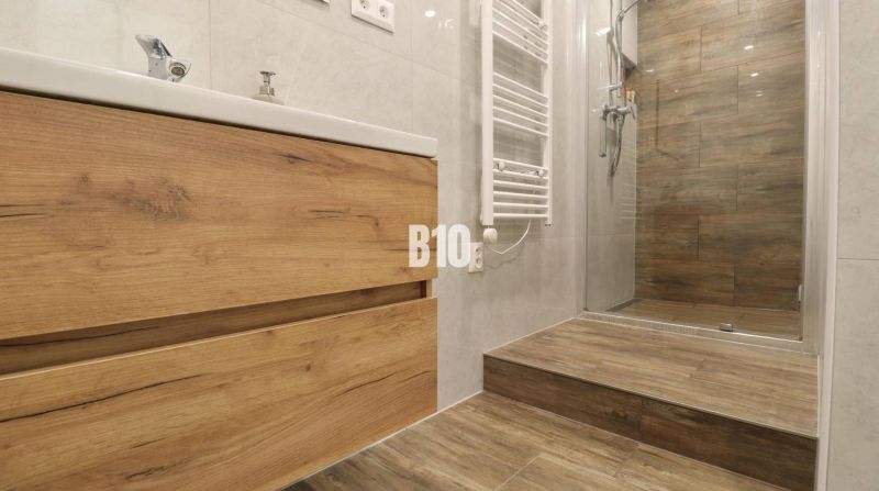 Bathroom in a 3-room apartment with flooring and tiles featuring a wood design.
