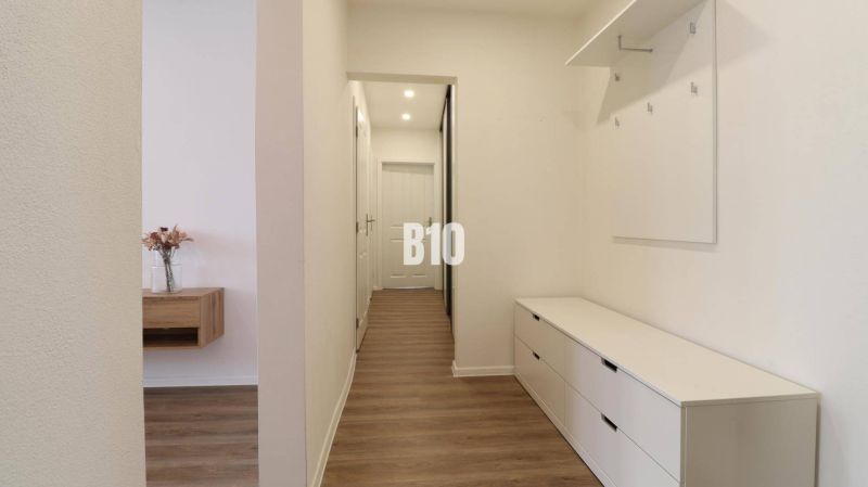 Hallway of a 3-room apartment with a wooden decor floor and storage spaces.