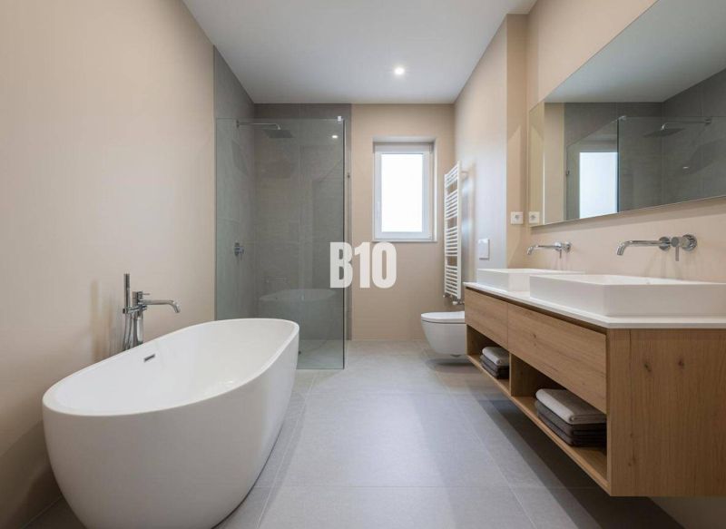 A bathroom with a freestanding bathtub and a shower in a family house.
