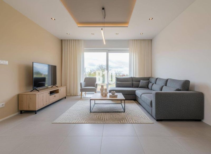 Living room with a comfortable sofa, television, and a large window in a family house.