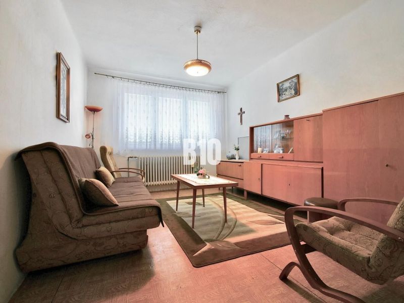 A living room in a 3-room apartment with vintage furniture and a wooden decor floor.