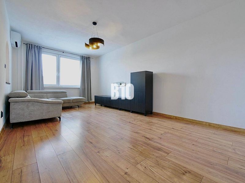 Living room in a 3-room apartment with a comfortable sofa and a wooden decor floor.