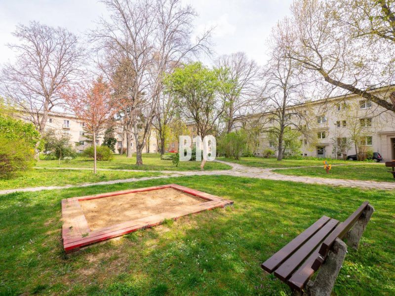 Courtyard in Nitra with a children's sandbox, benches, and surrounding residential buildings.