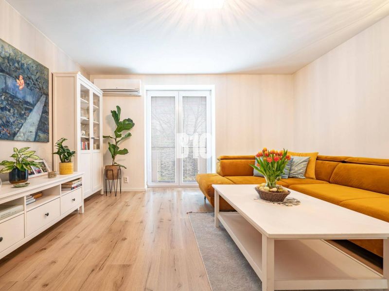 Living room in a 3-room apartment with a yellow sofa and a wooden decor floor.