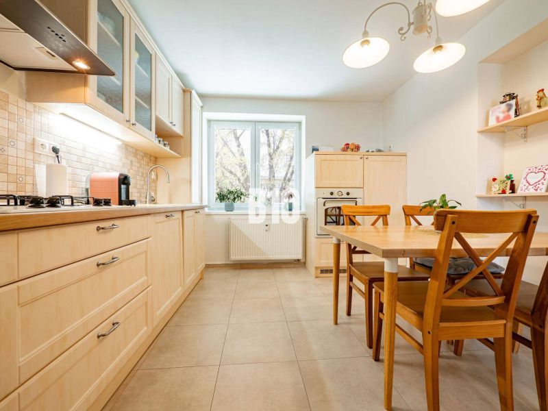 A kitchen in a 3-room apartment with a wooden decor floor and wooden furniture.