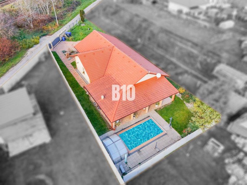 Aerial view of a family house in Nitra with two roofs and a swimming pool.