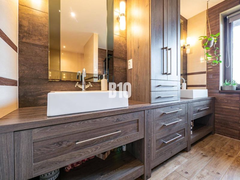 A family house bathroom with cabinets and a wooden decor floor.