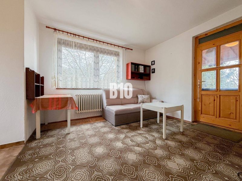 Living room in a family house with a sofa, table, and carpet.