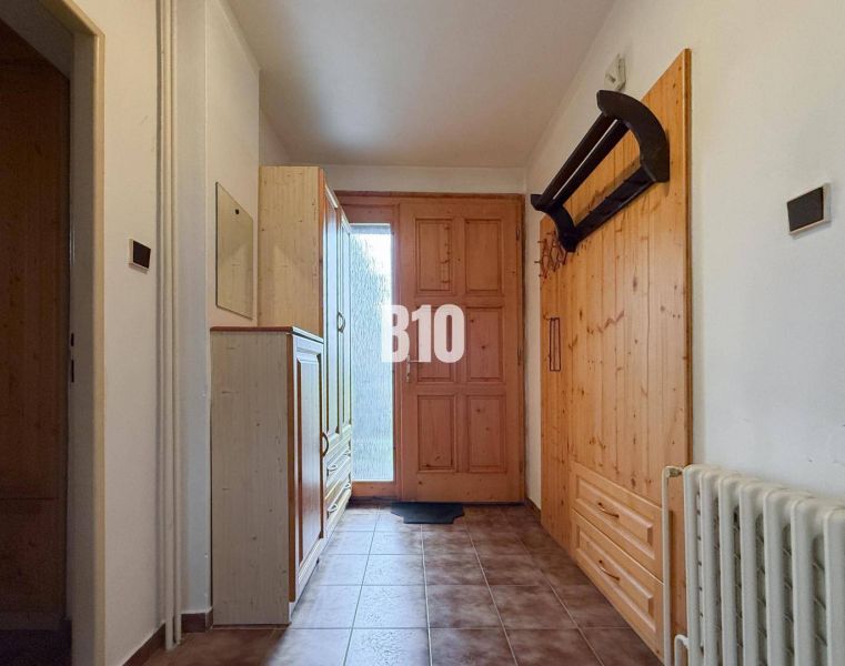 A hallway in a family house with wooden elements and furniture.