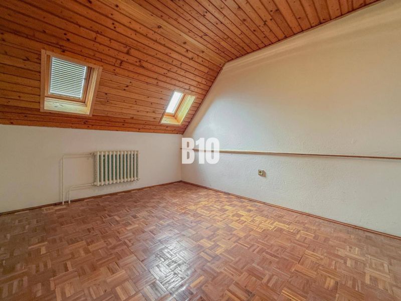 A room in a family house with wooden paneling and a floor with a wooden decor.