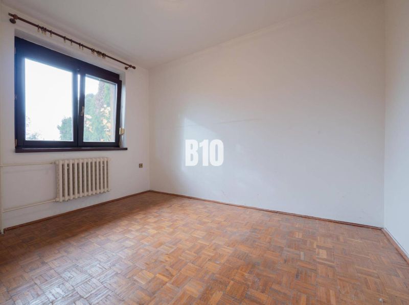 An empty room with a wooden floor in a family house, large window.