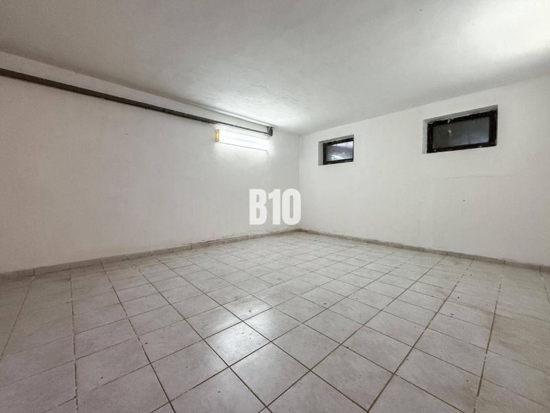 Empty room with white walls and tiles in a family house.