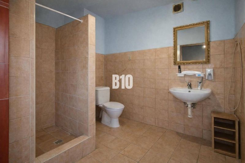 Bathroom in production facilities with a toilet, sink, and shower.