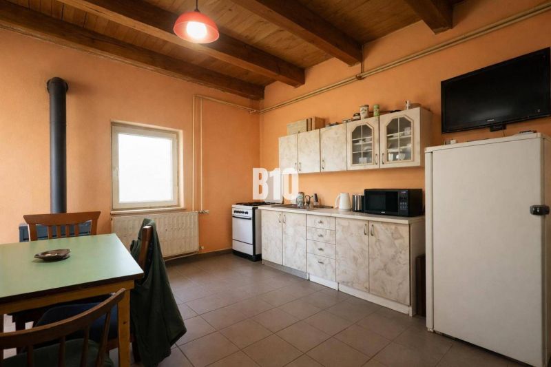 Kitchen space with simple cabinets, appliances, and a dining table.