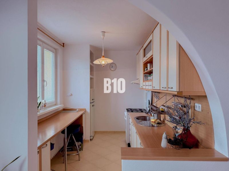 A kitchen in a 3-room apartment with a kitchenette and a bar counter.
