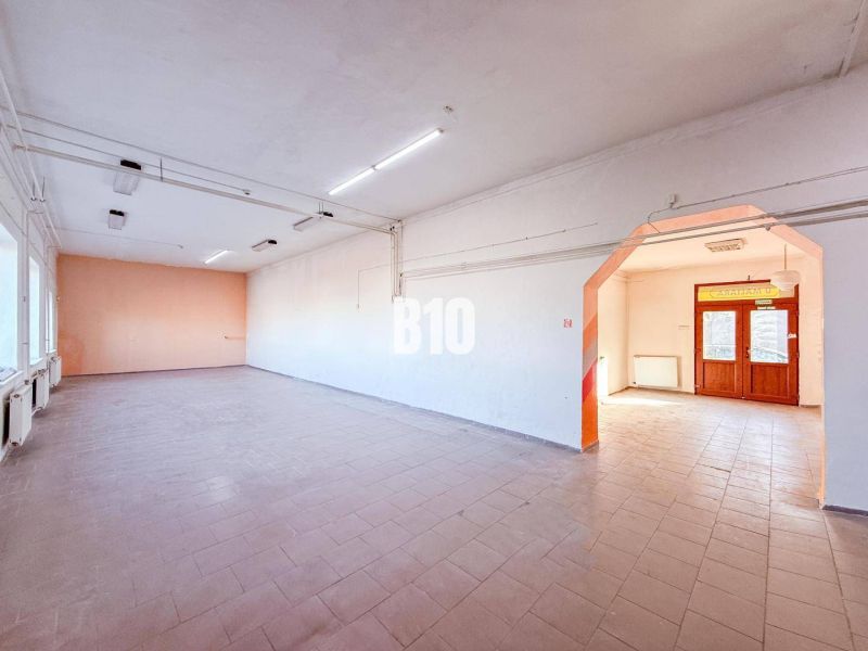 Spacious commercial premises with tiles and large windows, suitable for business.