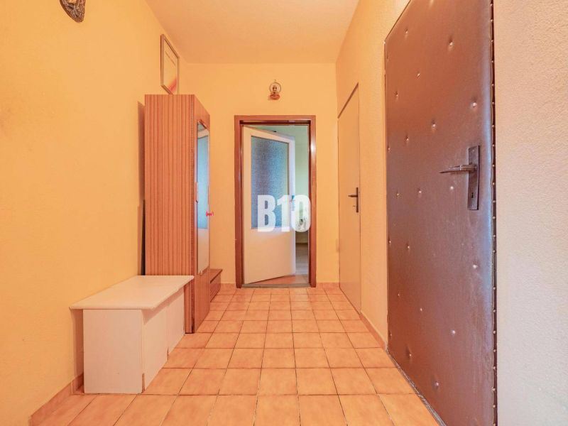 Entrance hall with tiles and a mirror in a 3-room apartment.