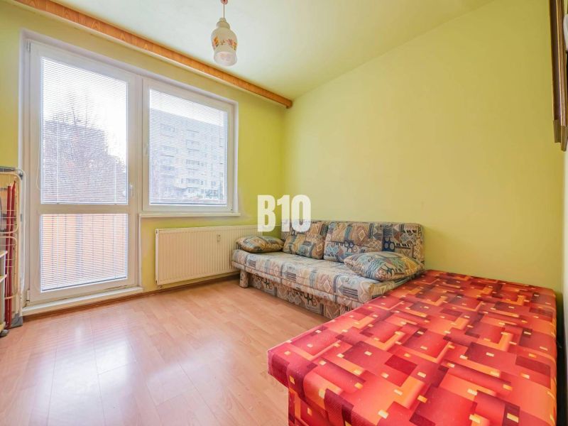 A room in a 3-room apartment with a sofa and a floor with a wood decor.