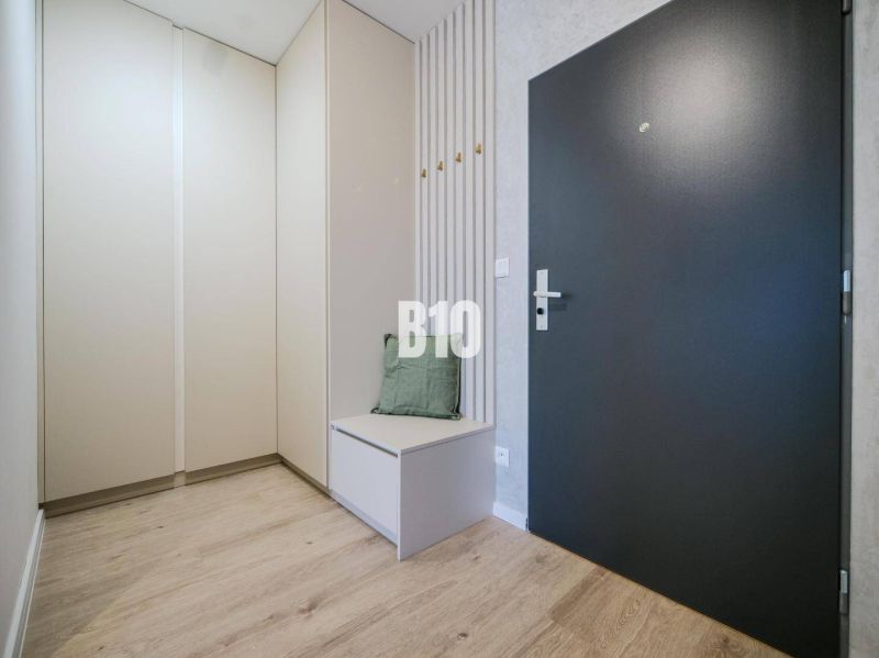 Entrance hallway of a 2-room apartment with a wooden decor floor and stylish storage space.